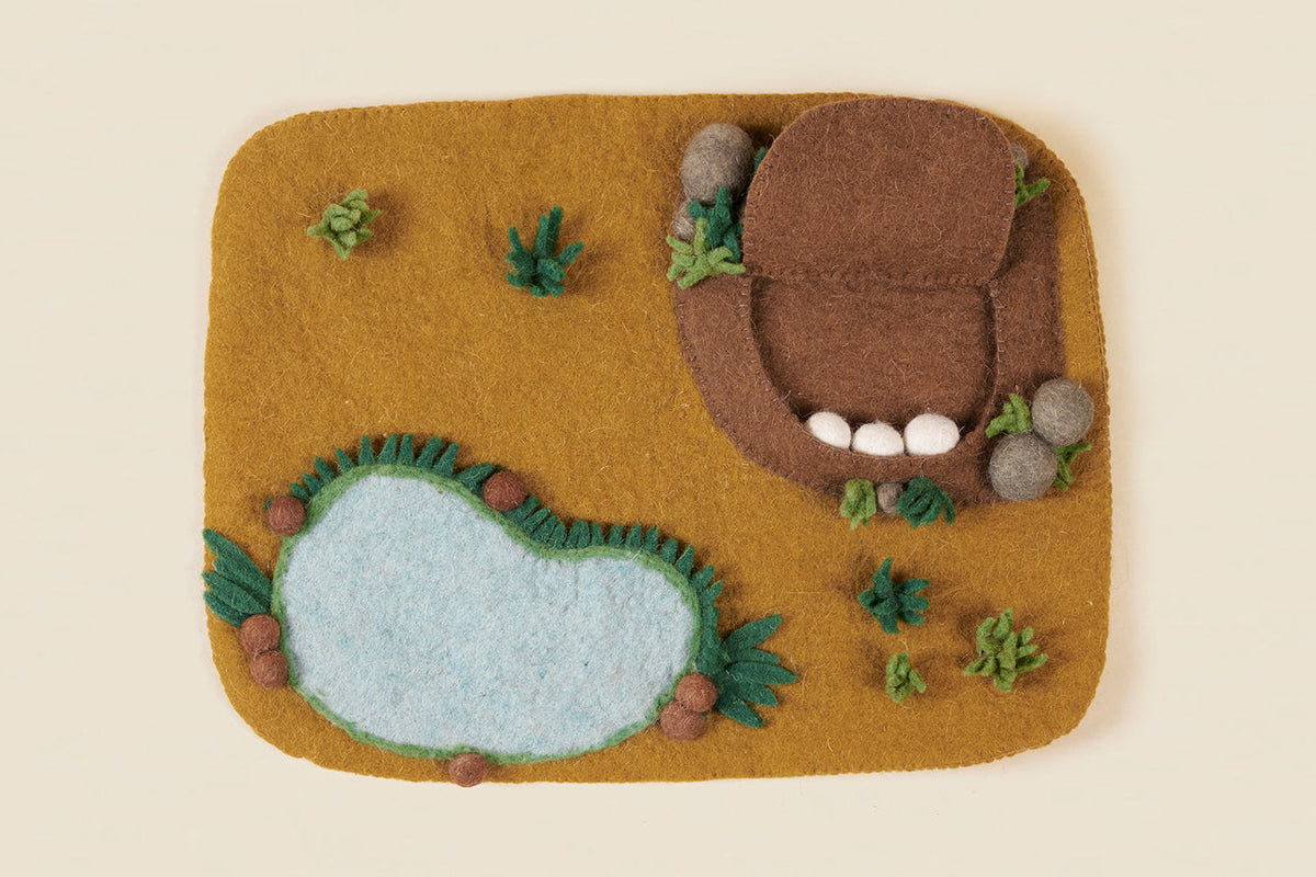 Safari play mat seen from above, showing watering hole and grassland